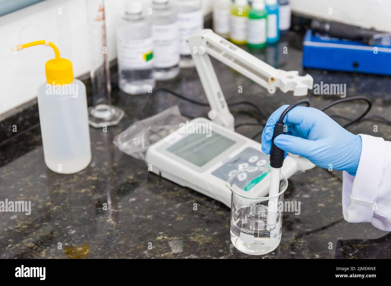 Woman hands performing pH test on pH meter electronic instrument Stock Photo