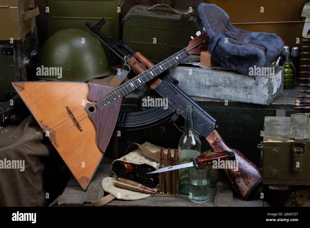 Russian army - kalashnikov AK 47 and balalaika with ammunition on army green crates background. Stock Photo