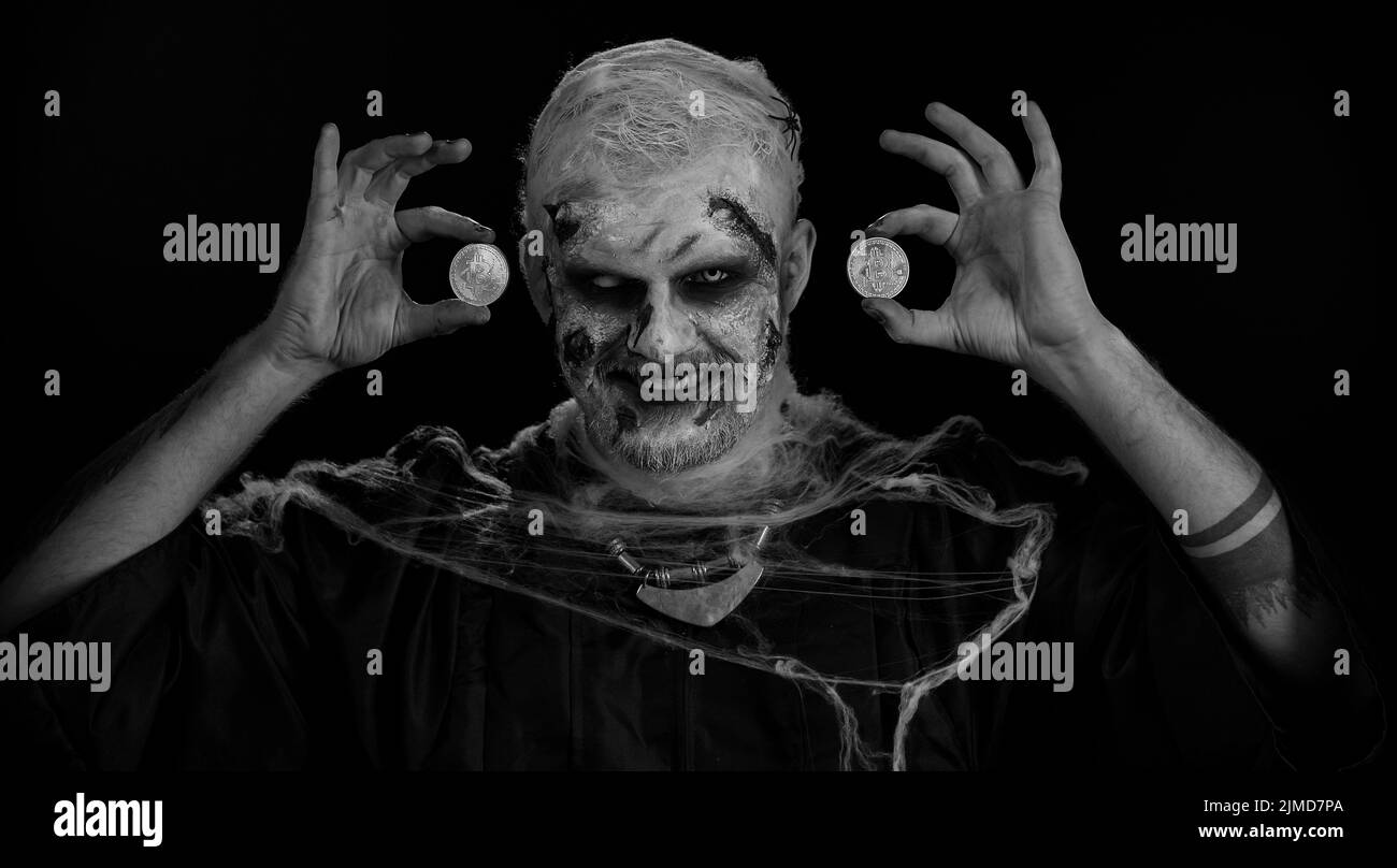 Scary man with bloody scars face, Halloween zombie showing golden bitcoins.  Achievement career wealth, cryptocurrency investment, mining, future  technology. Scary wounded undead guy smiles terribly Stock Photo - Alamy