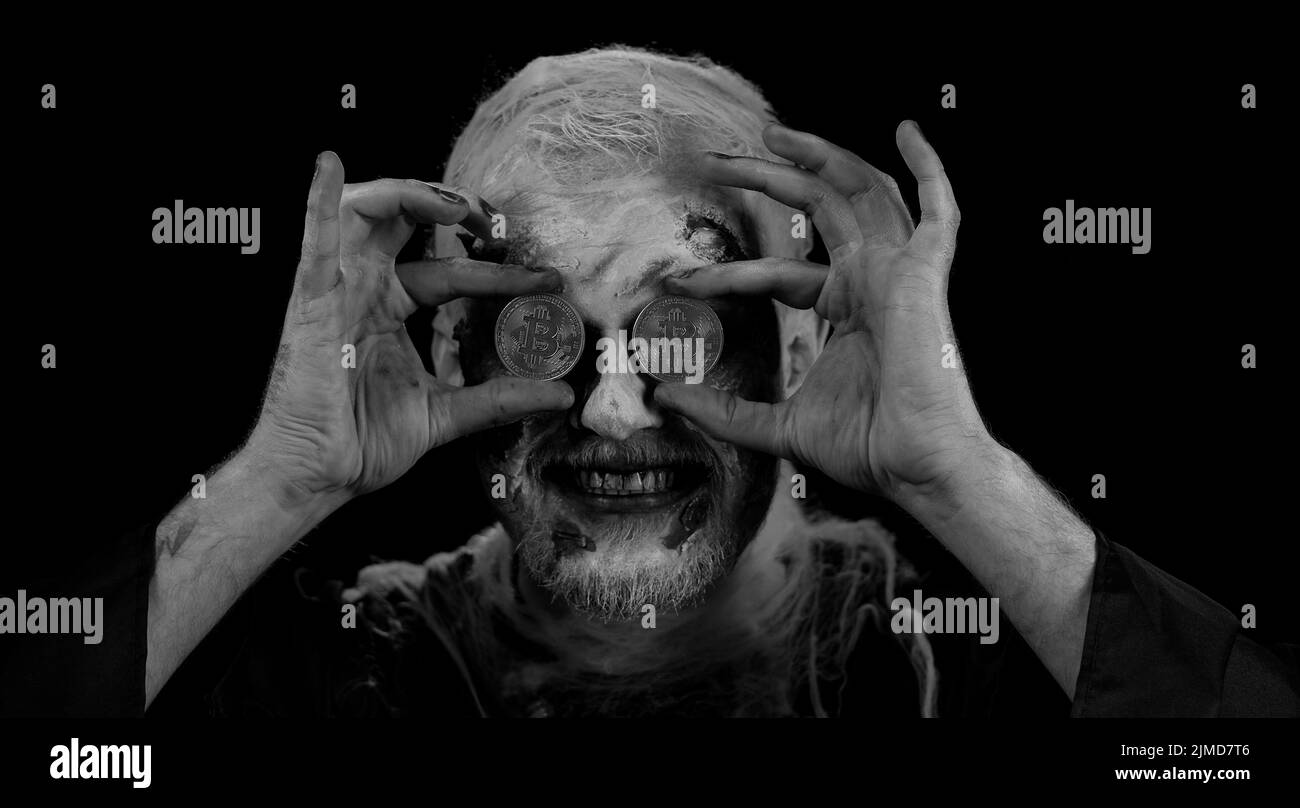 Zombie man with make-up with fake wounds scars showing golden bitcoins.  Achievement career wealth, cryptocurrency investment, mining btc, future  technology. Sinister dead guy. Halloween, filming Stock Photo - Alamy