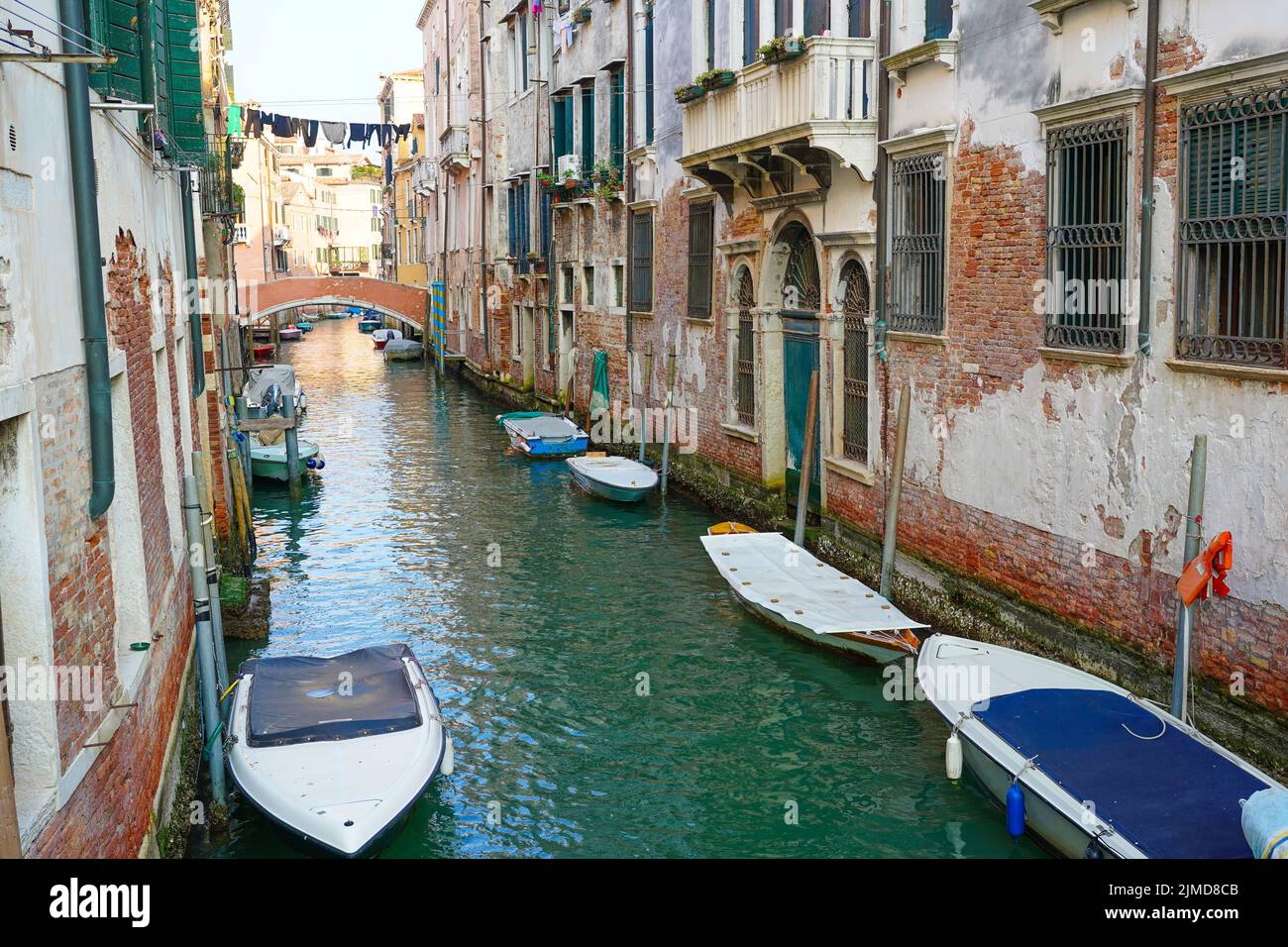 Canal through a residential area of Venice, showing the traditional way of drying clothes outside windows Stock Photo