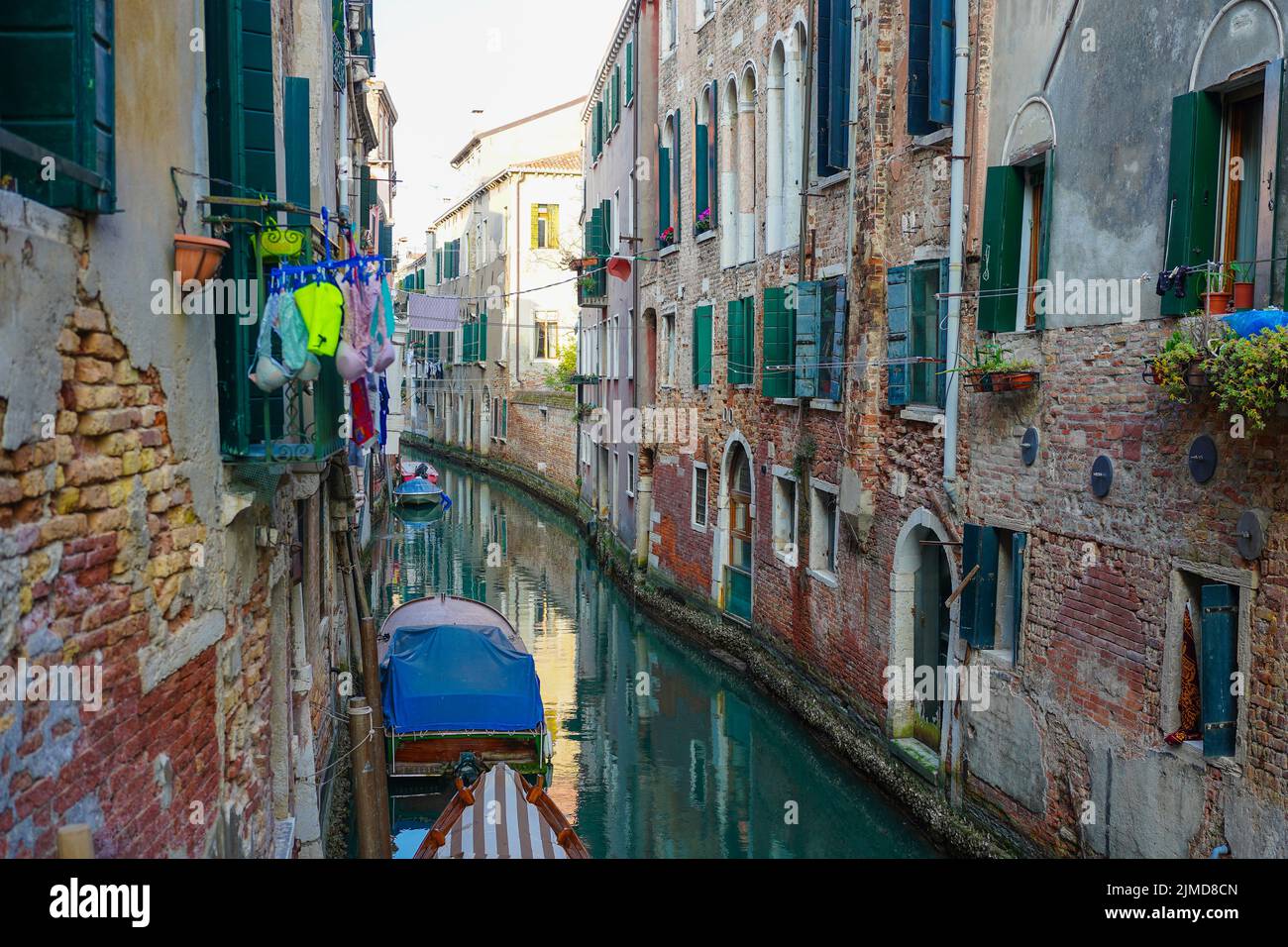 Canal through a residential area of Venice, showing the traditional way of drying clothes outside windows Stock Photo