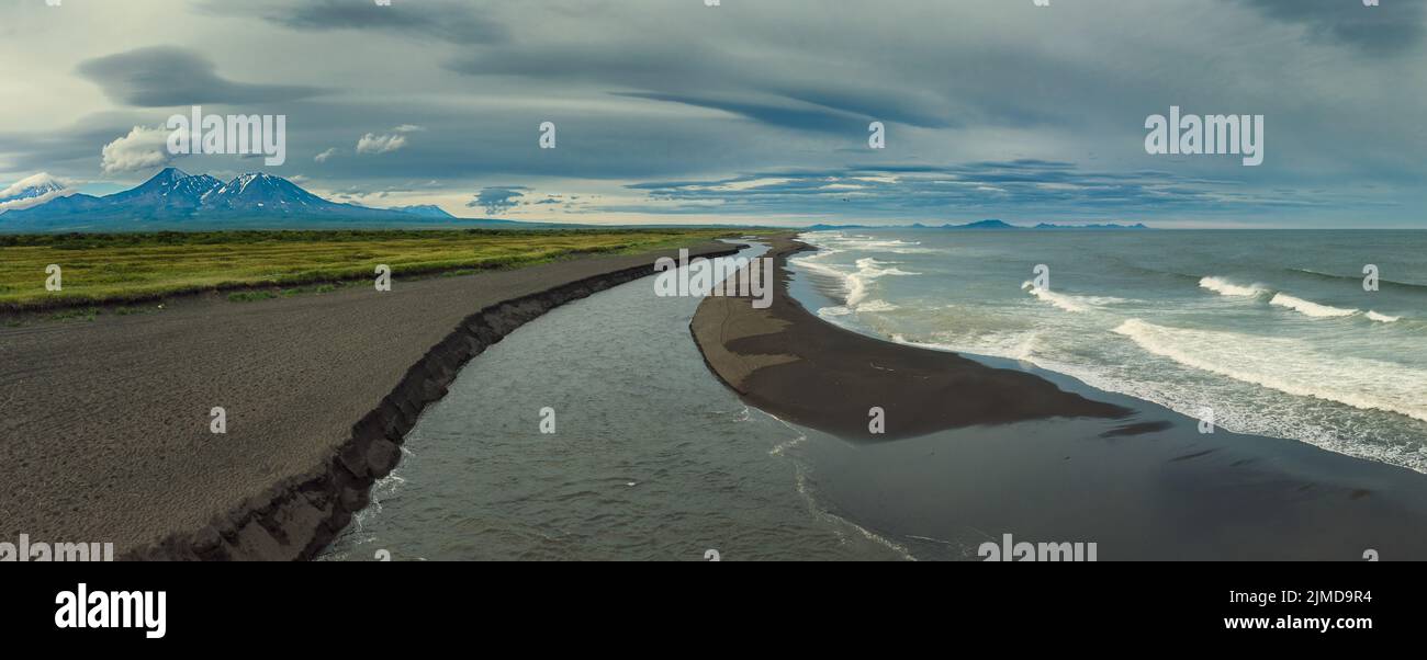 Beach with black sand and volcano Stock Photo
