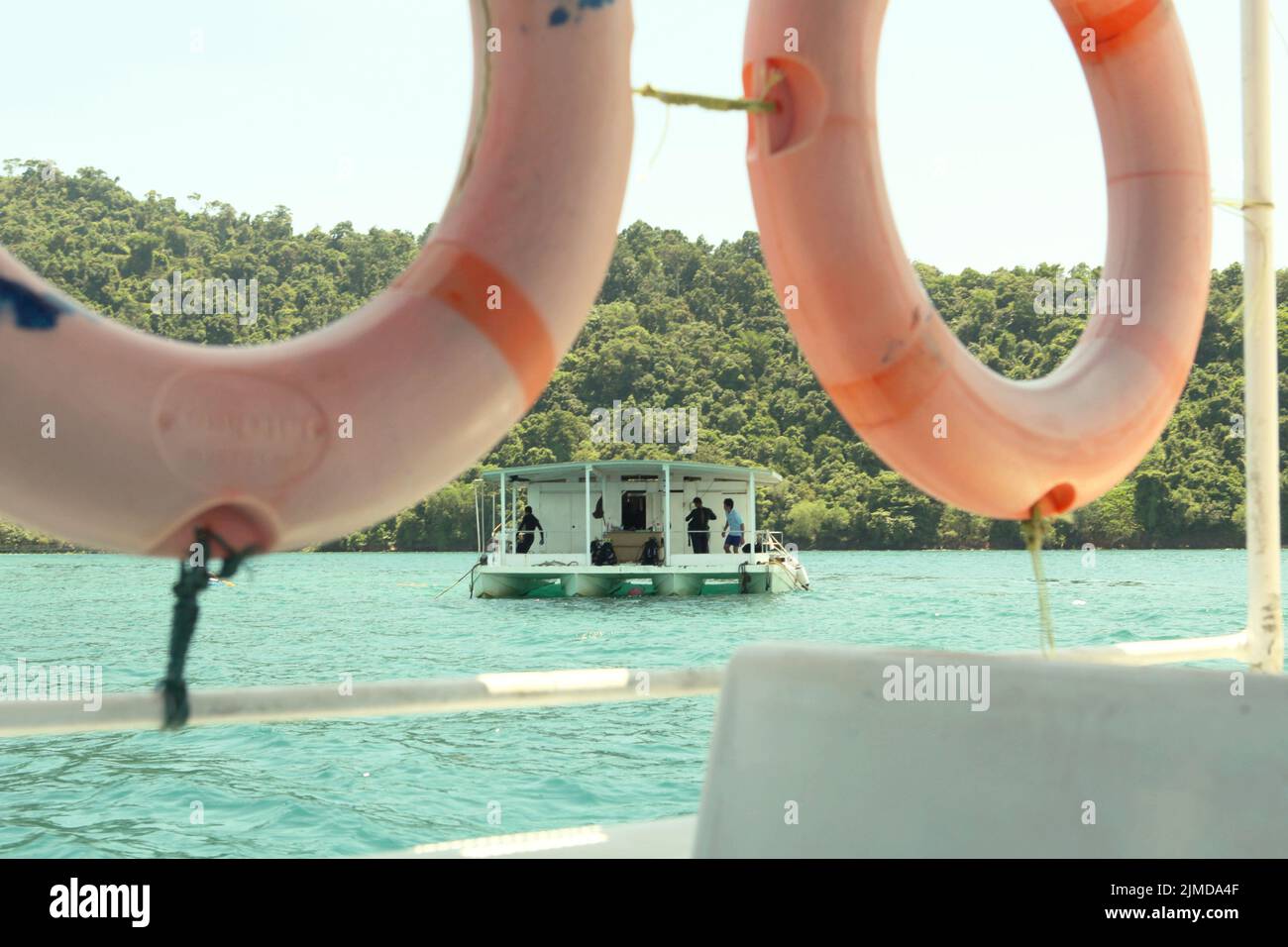 A boat for sea walking attraction is floating on the sea near Pulau Sapi (Sapi Island), a part of Tunku Abdul Rahman Park in Sabah, Malaysia. Stock Photo