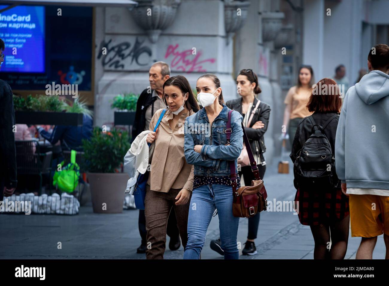 Picture of a white caucasian people walking, young and old women, in the streets of Belgrade, Serbia, while wearing a protective face mask, during the Stock Photo