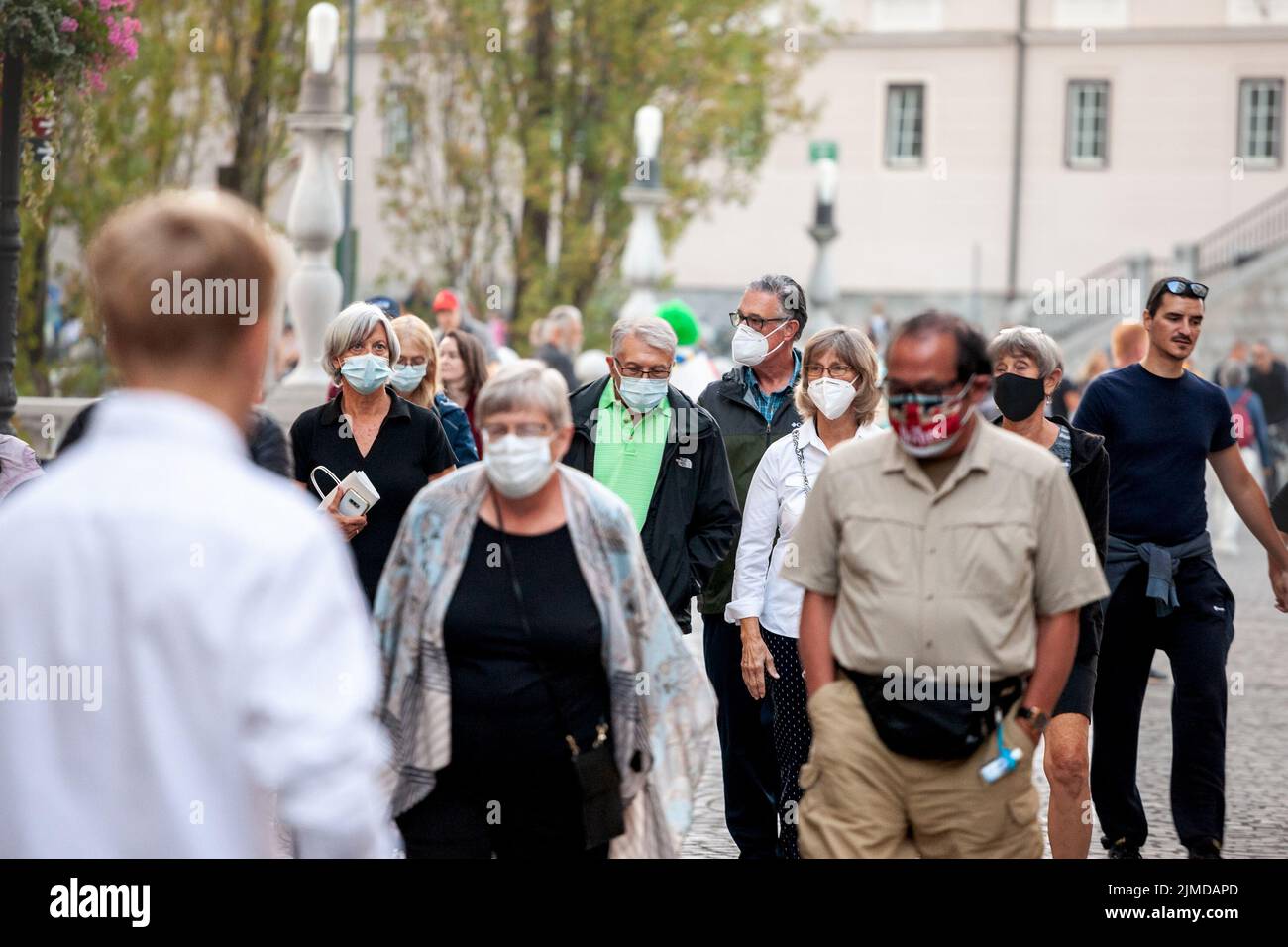 Picture of white caucasian senior men in Ljubljana, capital city of Slovenia while wearing a respiratory face mask during the coronavirus health crisi Stock Photo