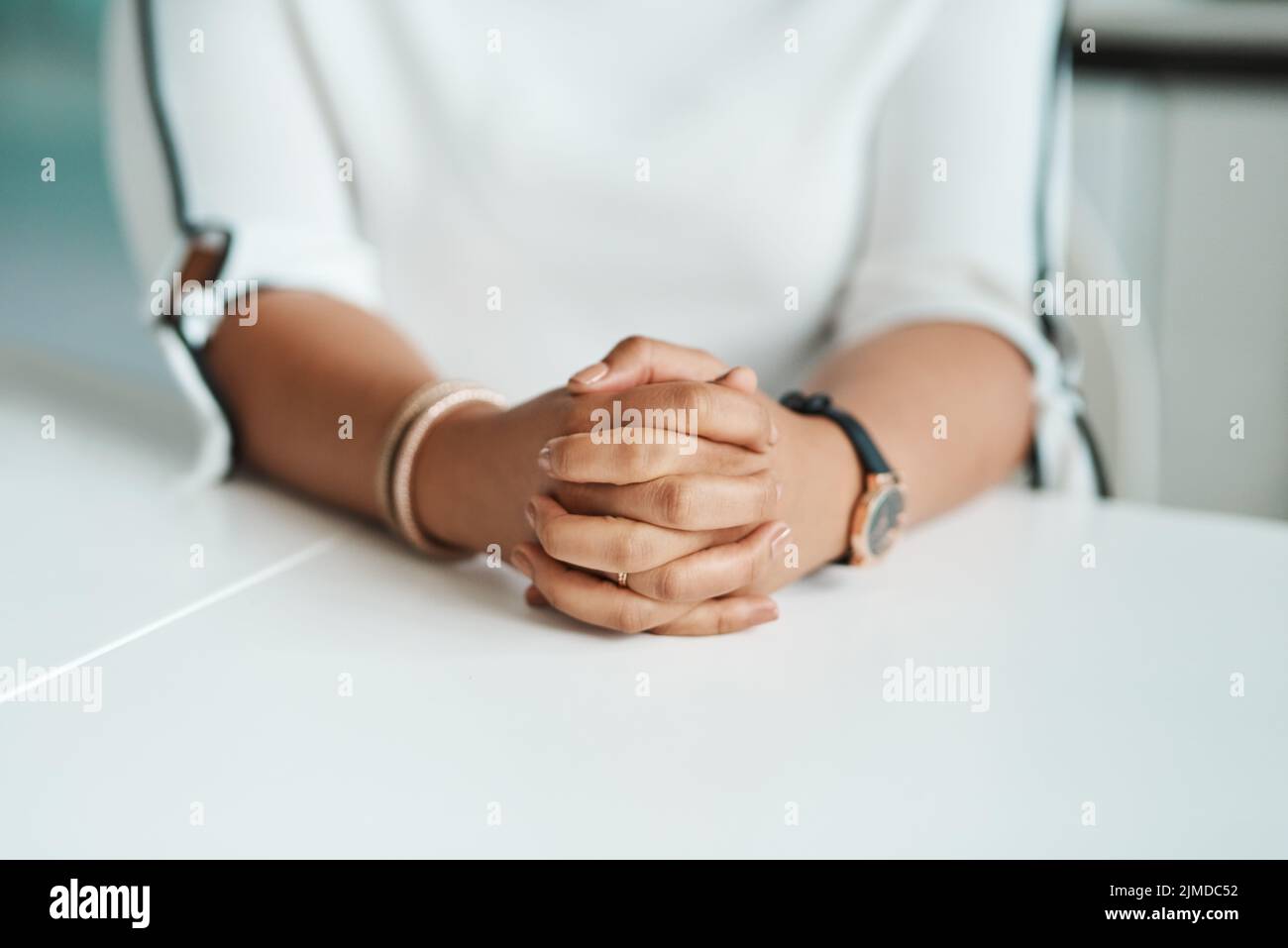 Waiting in anticipation for another great business opportunity. Closeup shot of an unrecognisable businesswoman sitting with her hands clasped in an Stock Photo