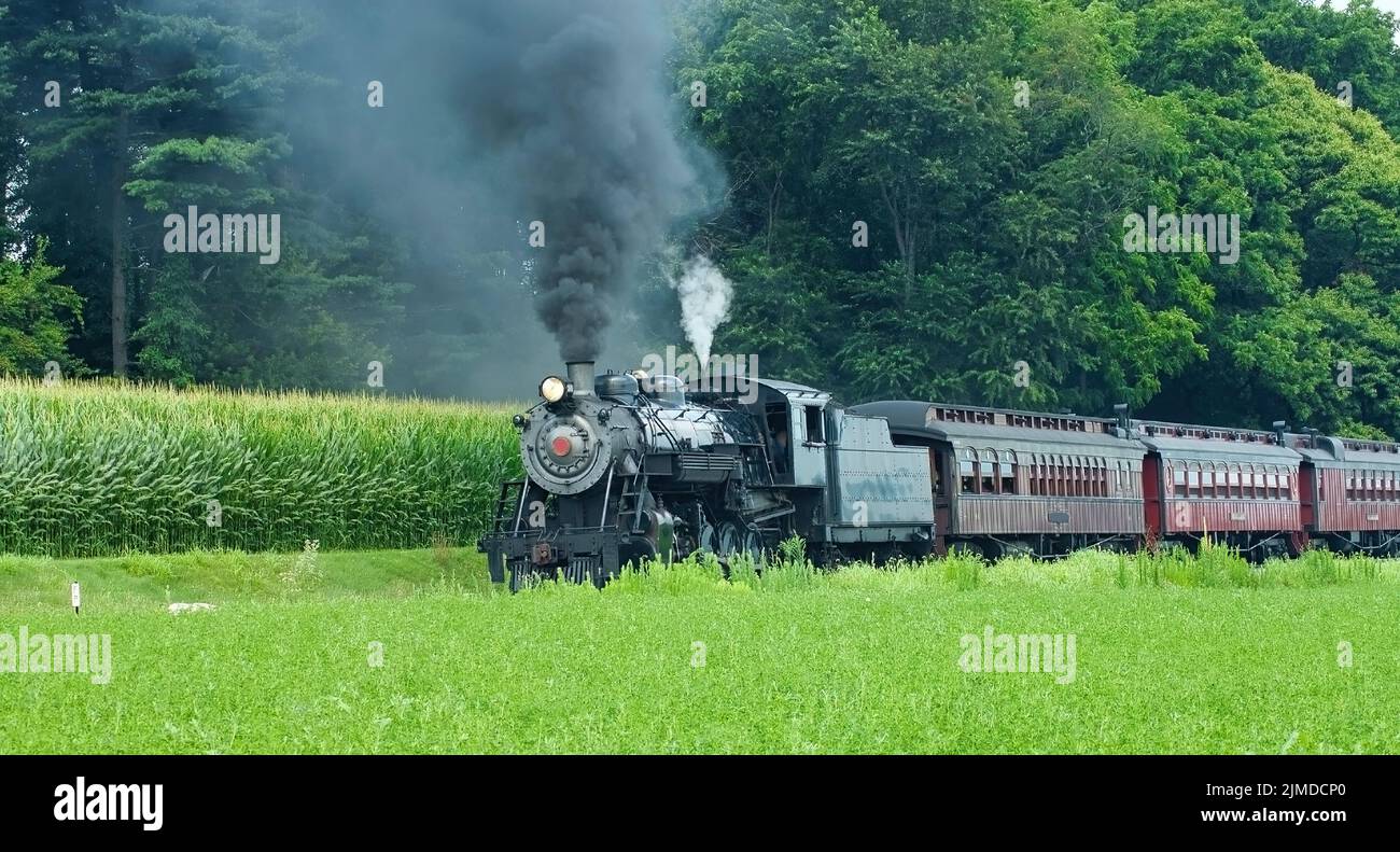 Steam Passenger Train Puffing along Amish Countryside Stock Photo