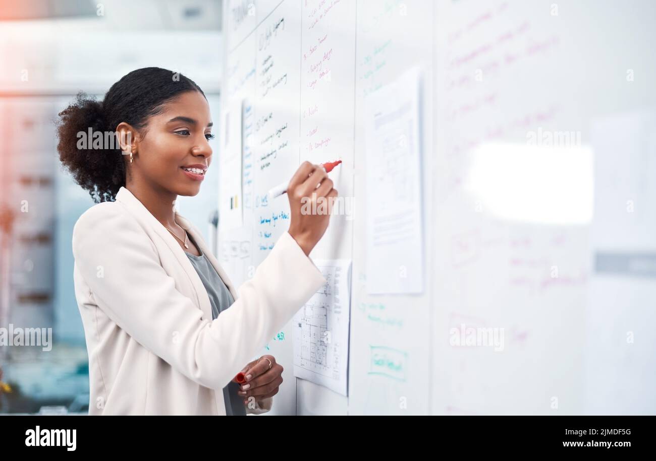 Project manager writing on a whiteboard to plan ideas and visualize
