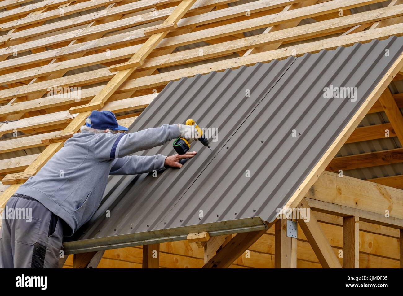 Male Hands In Gloves With A Screwdriver Screw The Roofing Sheet To The Roof  Stock Photo - Download Image Now - iStock