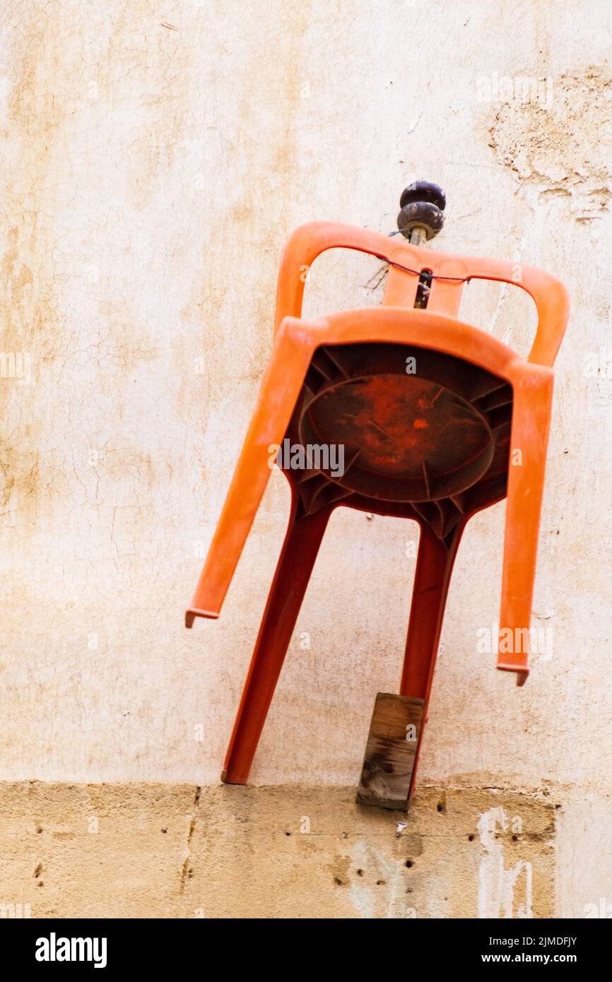 Orange chair hanging on the wall of a traditional house in the old city