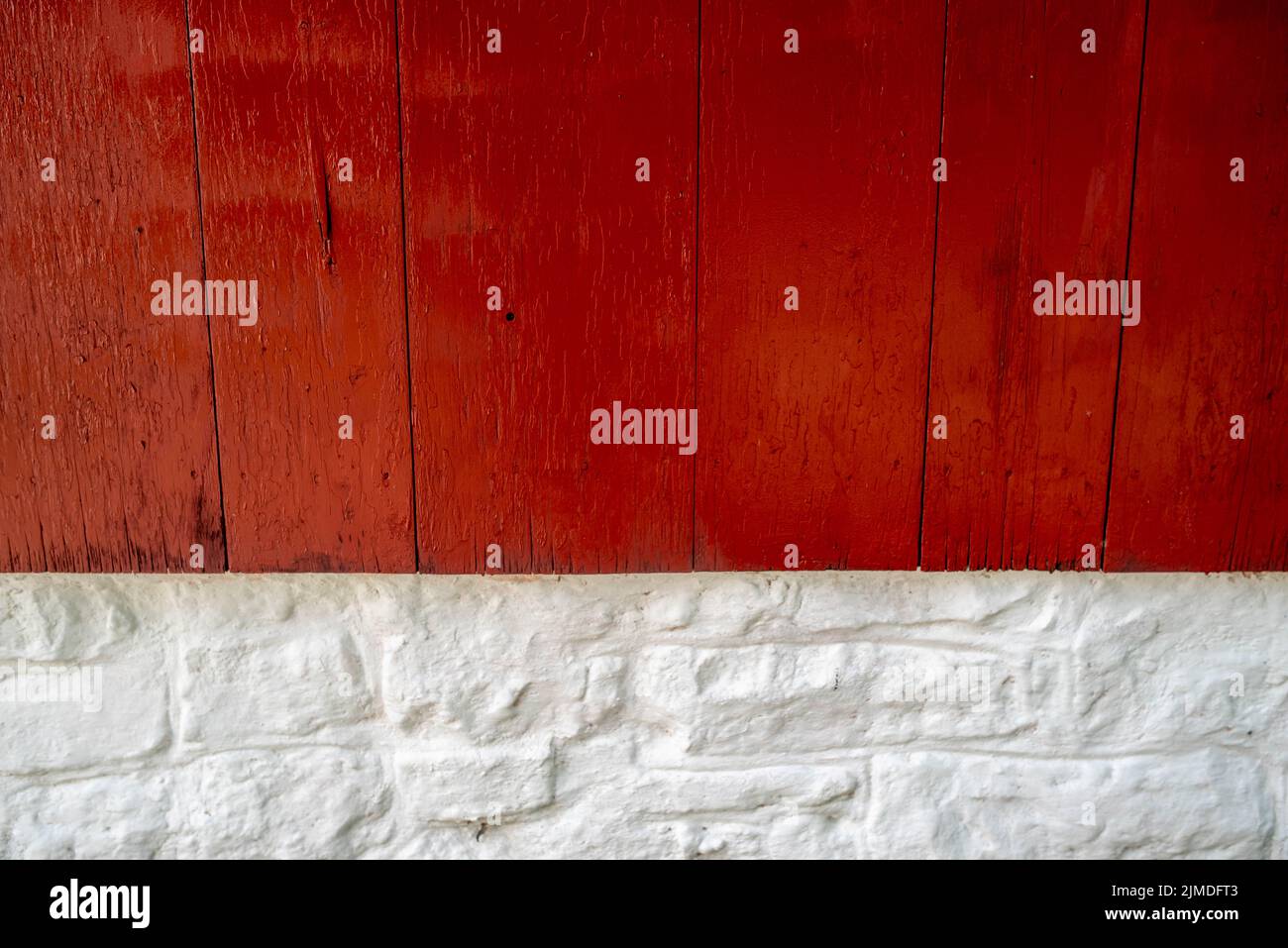 Bright red wood and whitewashed stone exterior wall close up. Stock Photo