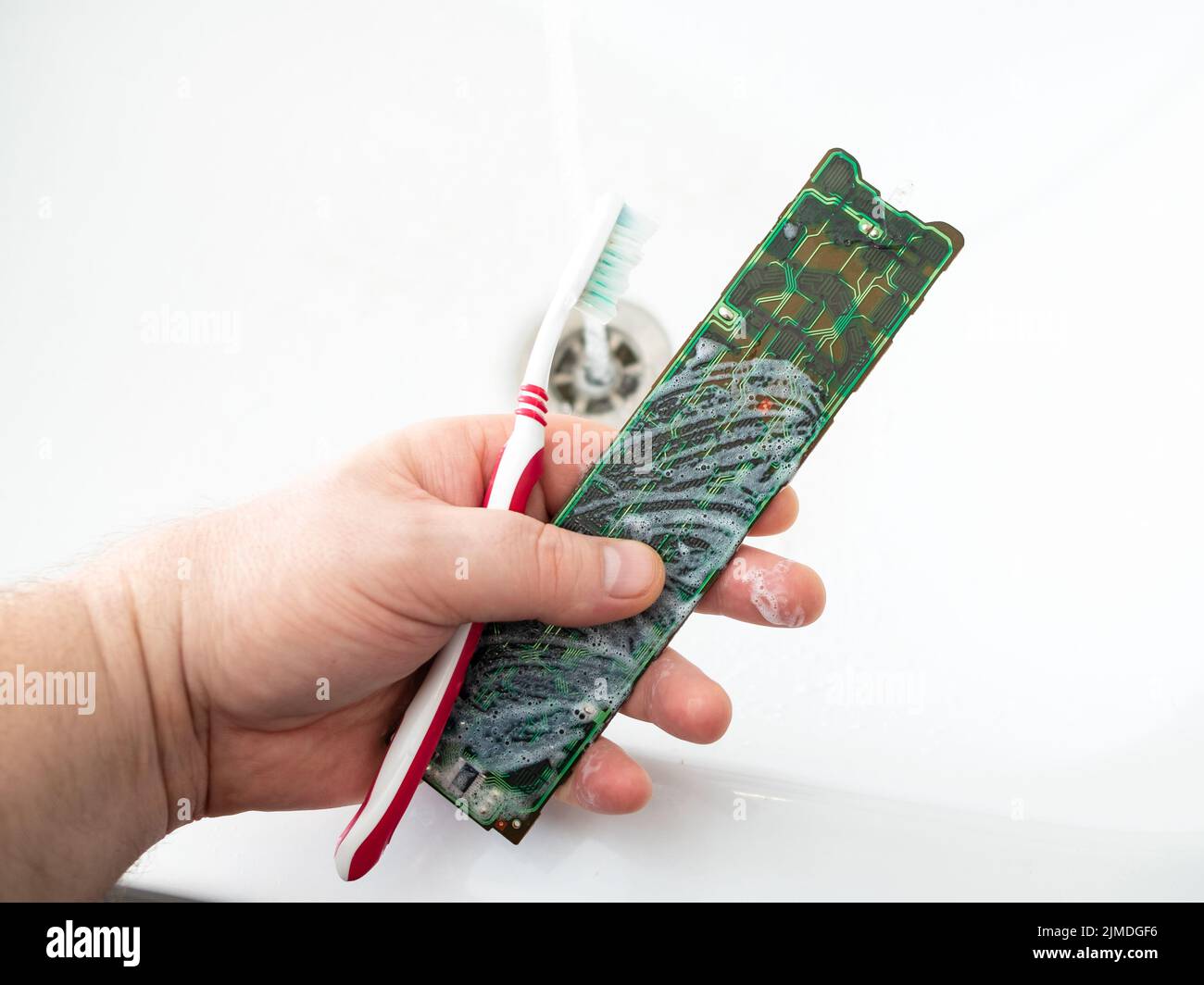 Cleaning the electronic board from the TV remote with a toothbrush and