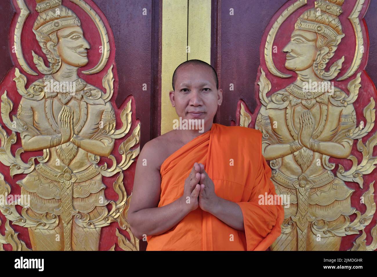 A Buddhist monk at Wat Mongkon (Mongkol) Nimit in Phuket Town, Phuket, Thailand, greeting the visitor with a wai, the traditional Thai greeting Stock Photo
