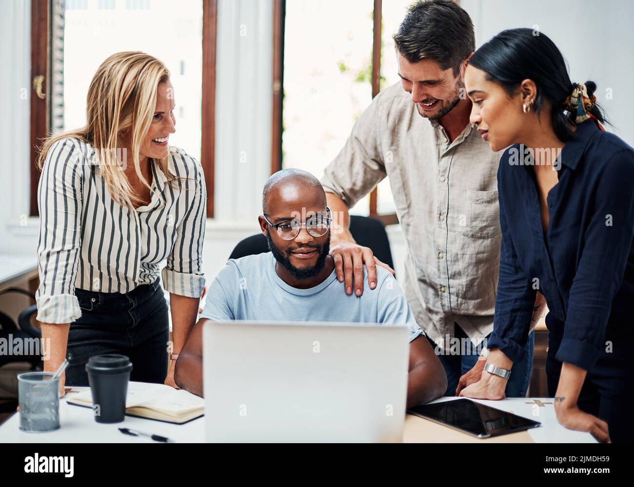 Business people gathered around laptop hi-res stock photography and ...