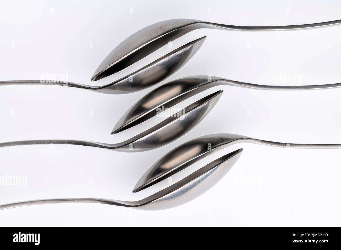 Artistic place setting photo of six spoons falling into each other Stock Photo