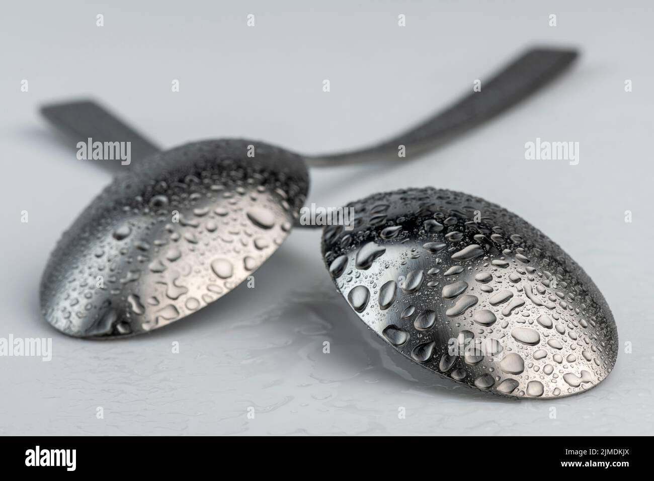Artistic place setting photo of two spoons with water droplets Stock