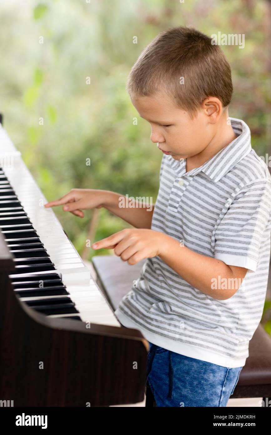 Little boy playing piano hi-res stock photography and images - Alamy