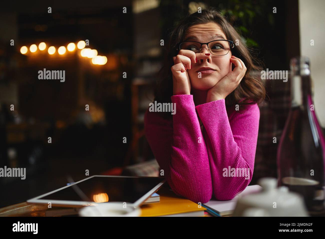 Smiling young lady sitting in cafe and having fun Stock Photo