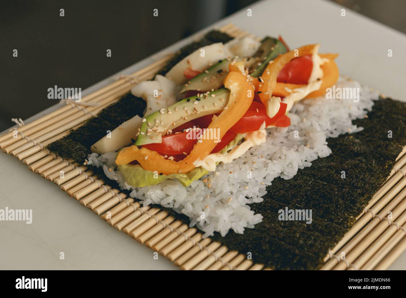 Process of preparing vegan sushi roll futomaki with pepper cucumber and avocado salad Stock Photo