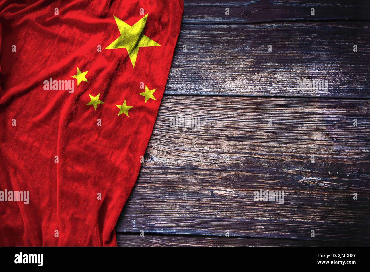 Chinese flag on rustic wooden background for Martyrs Day, China National Day or Labor Day concept. Stock Photo