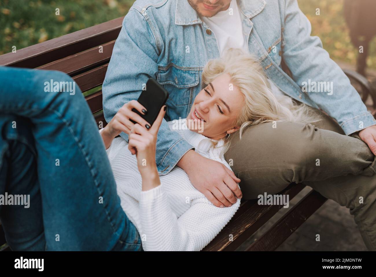 Young couple in love enjoying their date, using mobile phone Stock Photo