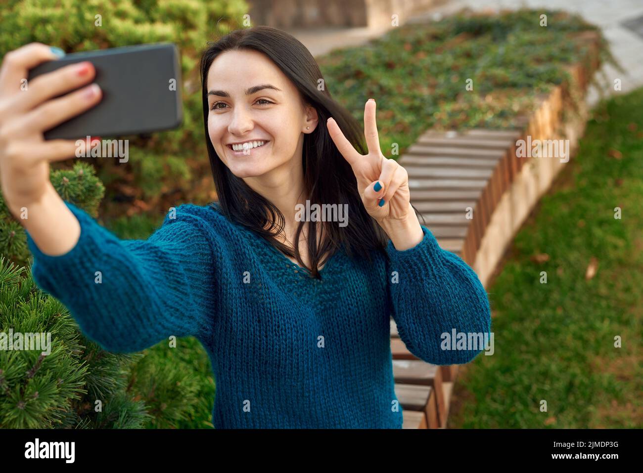 Smiling lady posing for self picture outdoors Stock Photo