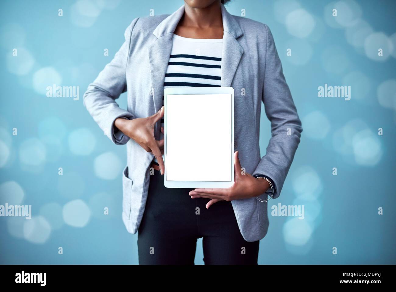 Blank screen and copy space on a tablet with a woman showing a digital device. Closeup of female hands holding tech product. Person posing with and Stock Photo