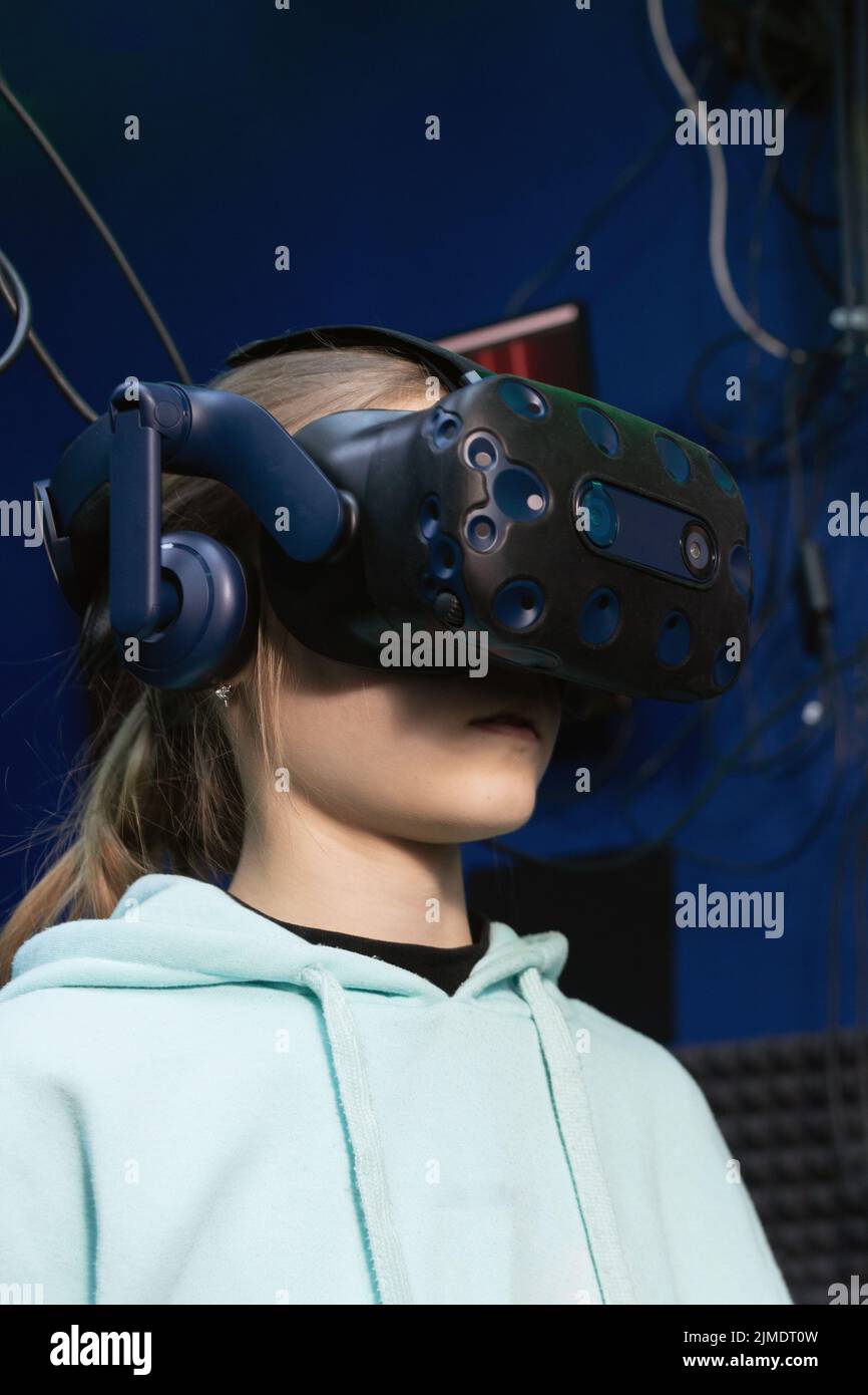 empeñar progenie Opaco Young girl in VR headset watches video with full immersion in virtual  reality club Stock Photo - Alamy