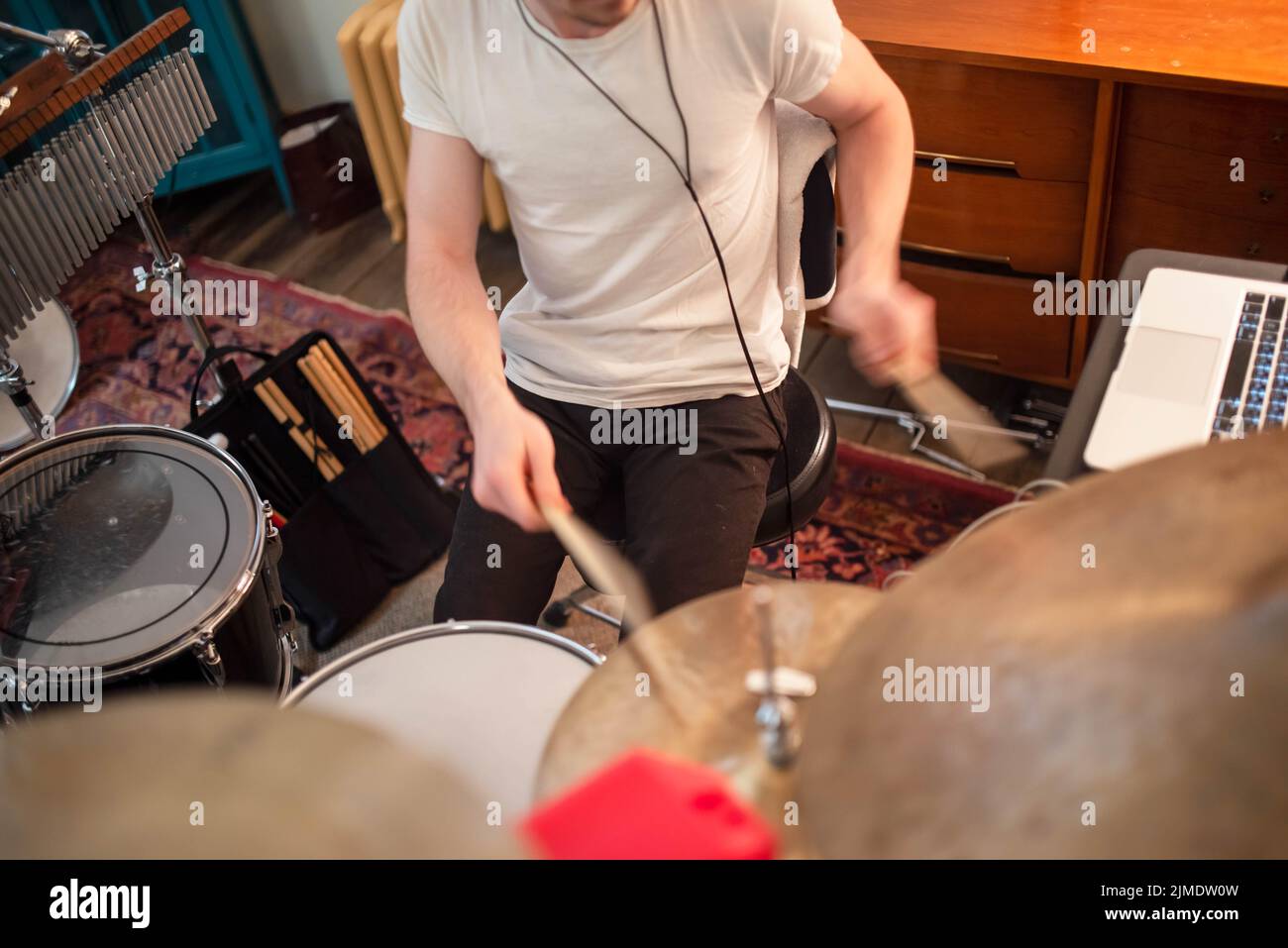 Young man plays drums in home studio close up. Stock Photo