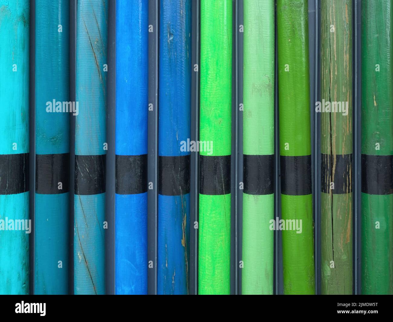 Colorful wooden poles as part of an enclosure, Germany Stock Photo