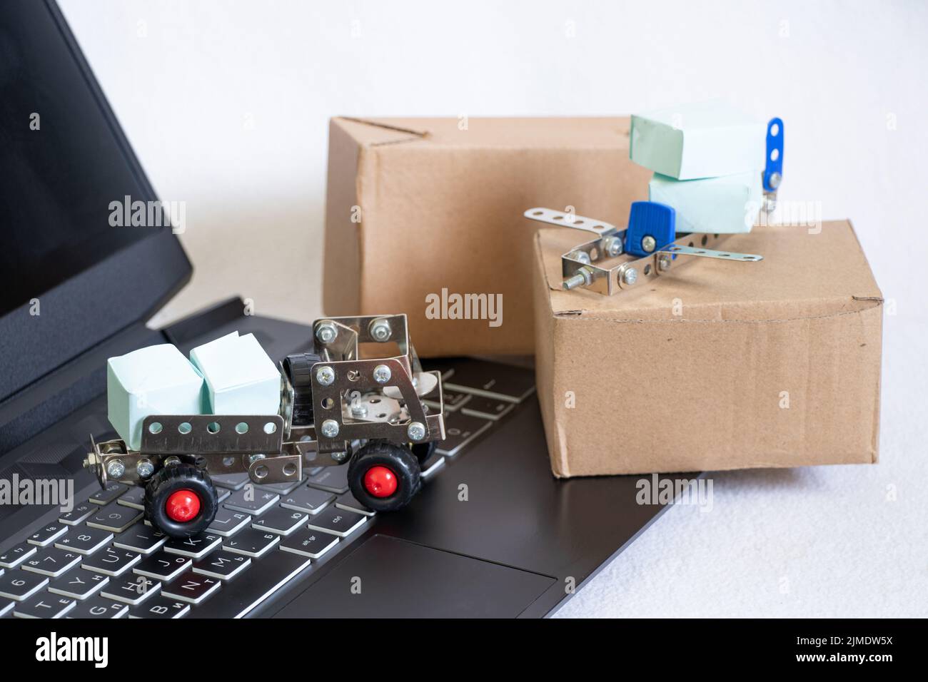 Shipping, delivery and logistic concept. Truck and plane and cardboard boxes on laptop keyboard. Online technologies. Online delivery of goods, courie Stock Photo