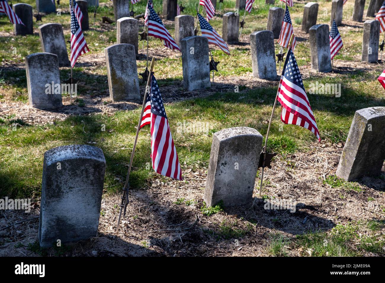 Rows of Civil War soldiers gravestones tombstones with flags in cemetery Stock Photo