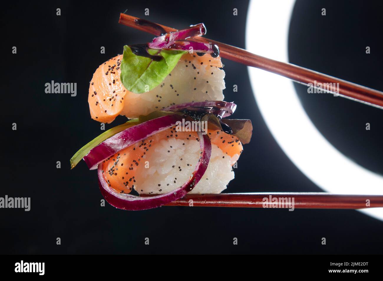 Sushi with red onion garnish Stock Photo Alamy
