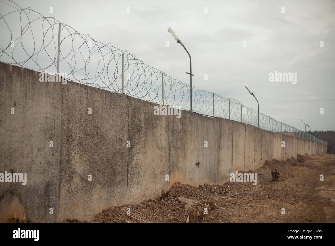 Fence with barbed wire. Fencing around the territory. Stock Photo