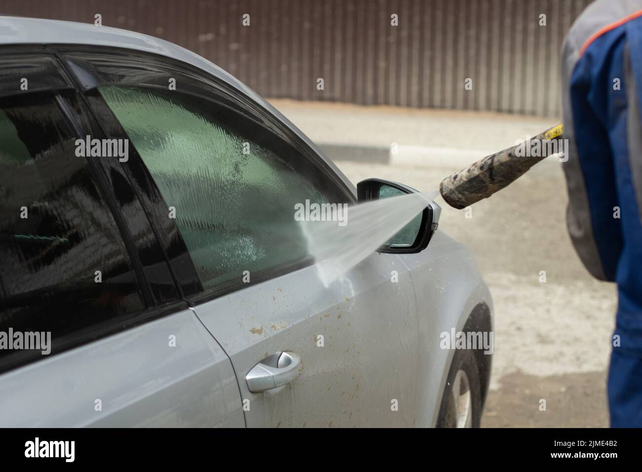 Car wash. The car is washed under the pressure of a jet of water Stock