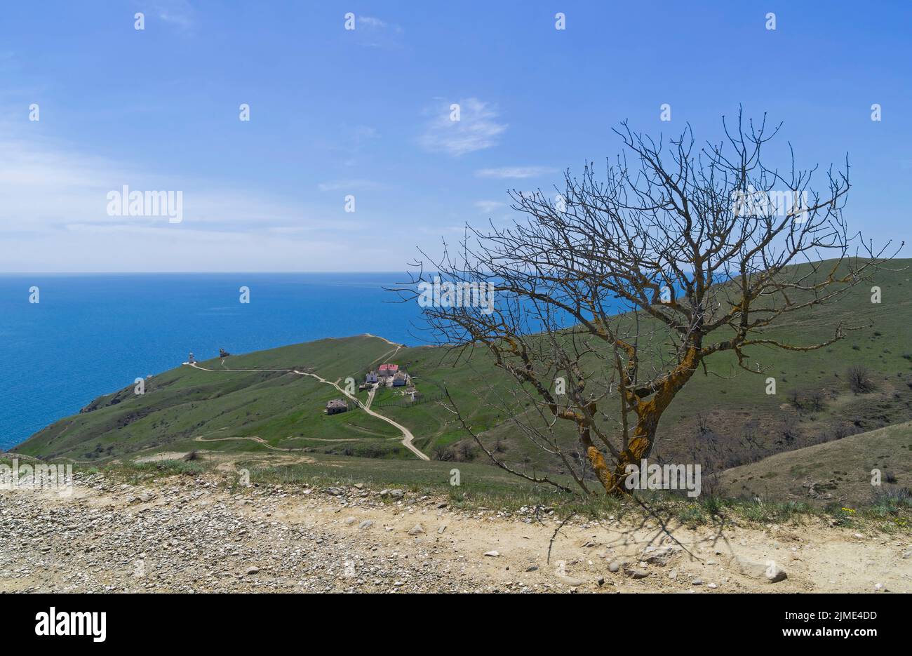 A dirt road running along a deserted mountainside on the seashore. Stock Photo