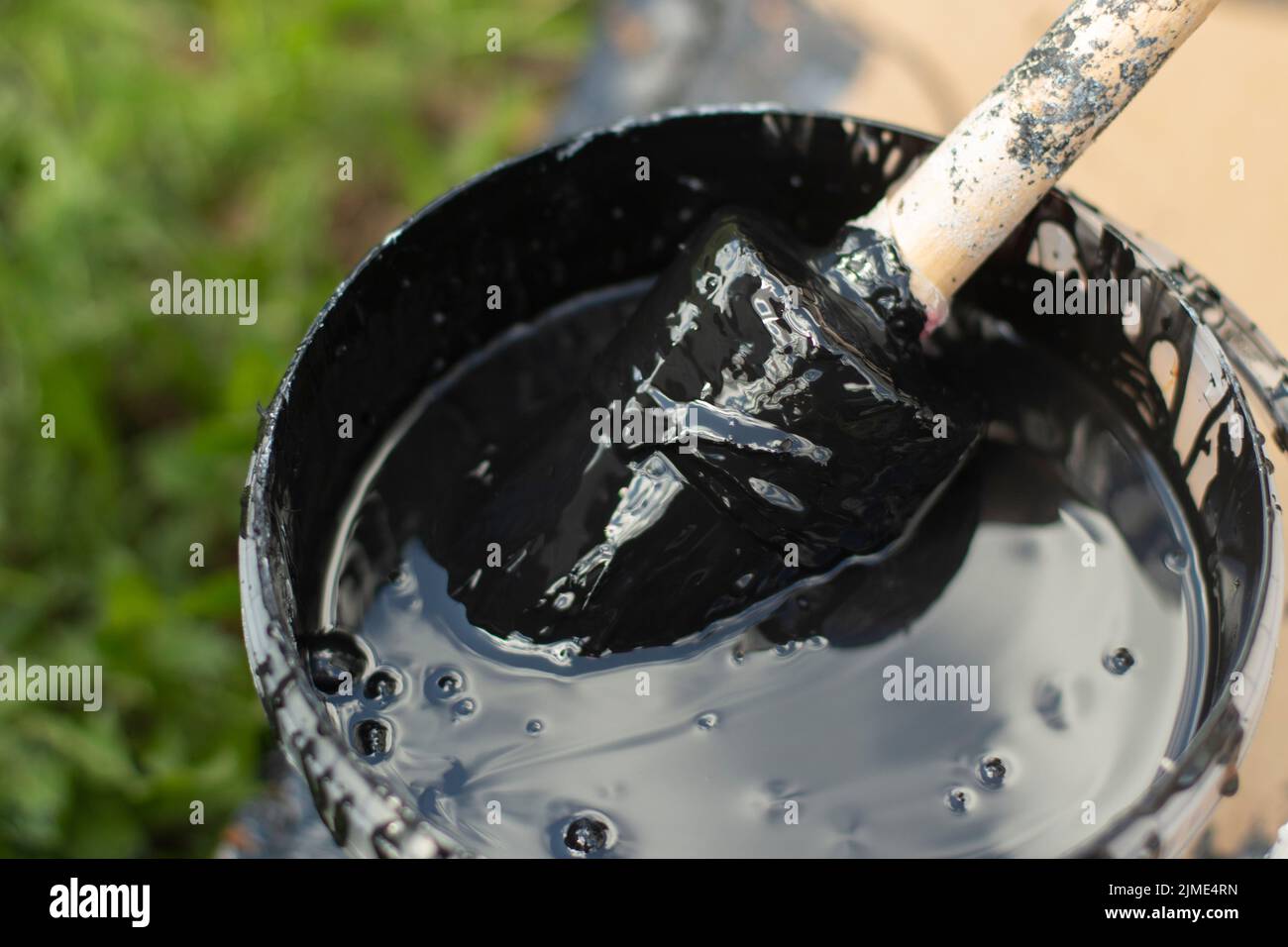 Paint brush in a bucket. Black paint for wood Stock Photo Alamy