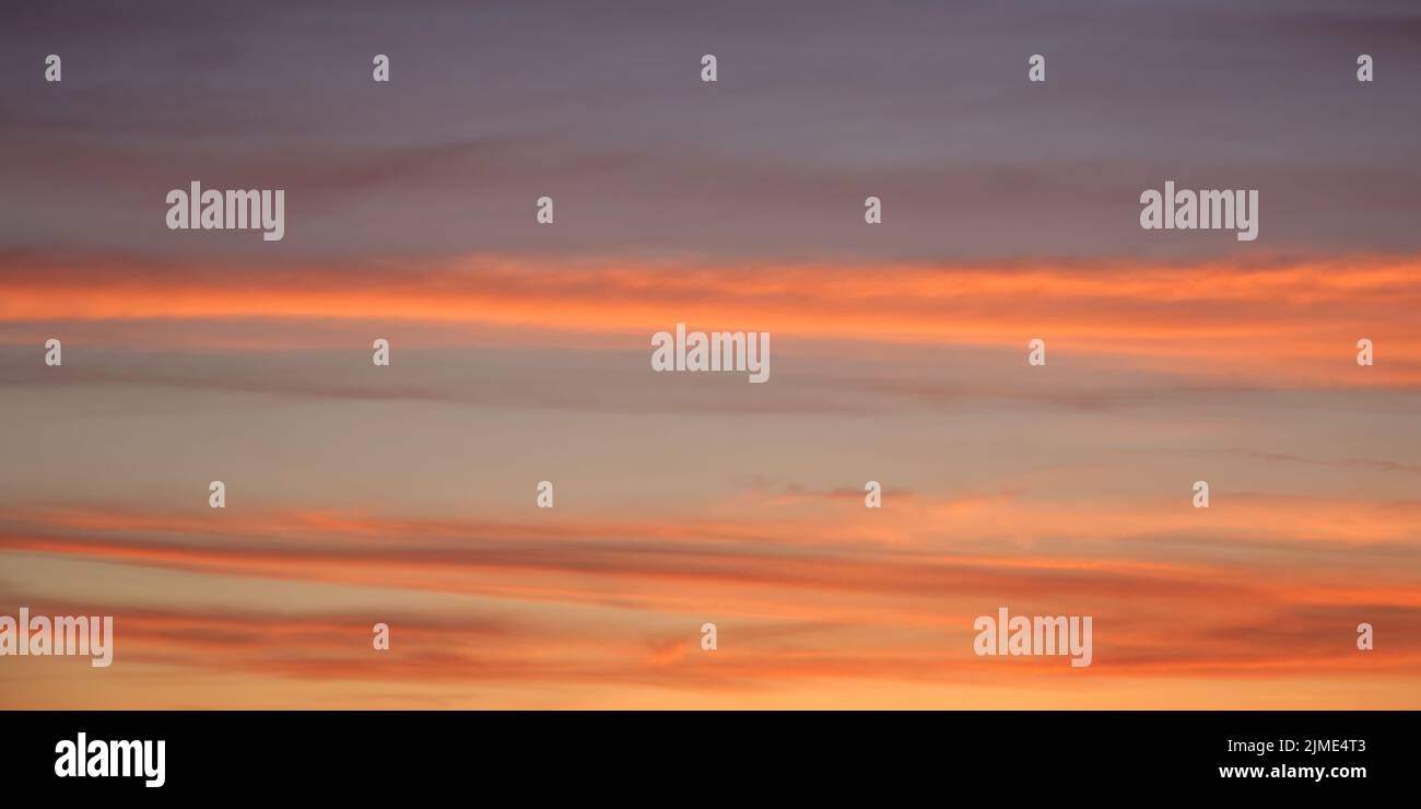 Bright sunset sky, full frame. Orange, pink, red clouds. Stock Photo