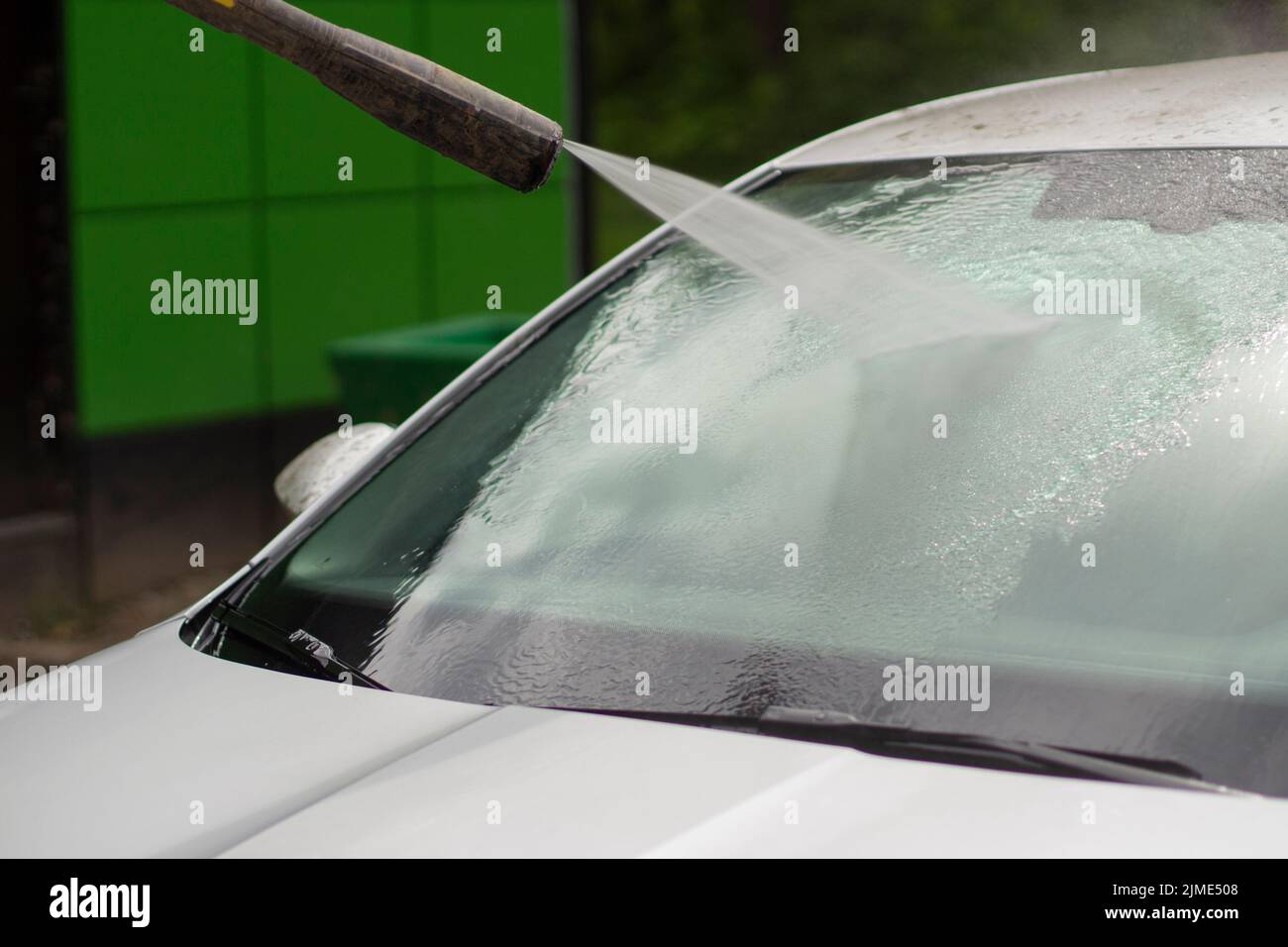 Car wash. The car is washed under the pressure of a jet of water Stock