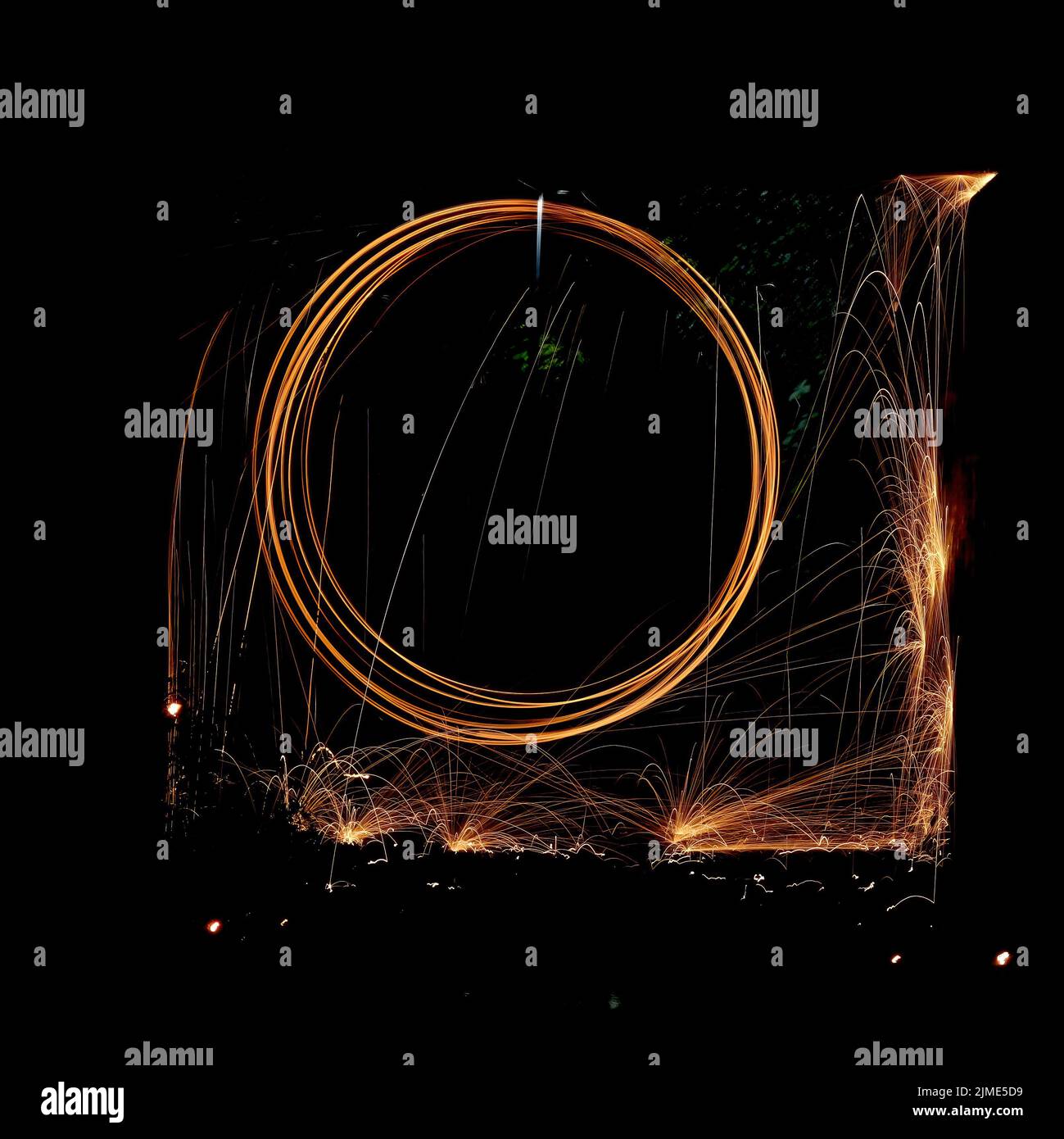 Steel wool spinning in a tunnel, throwing off yellow and orange sparks