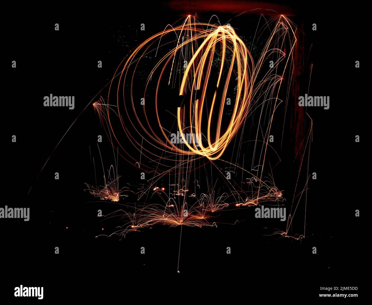 Steel wool spinning in a tunnel, throwing off yellow and orange sparks