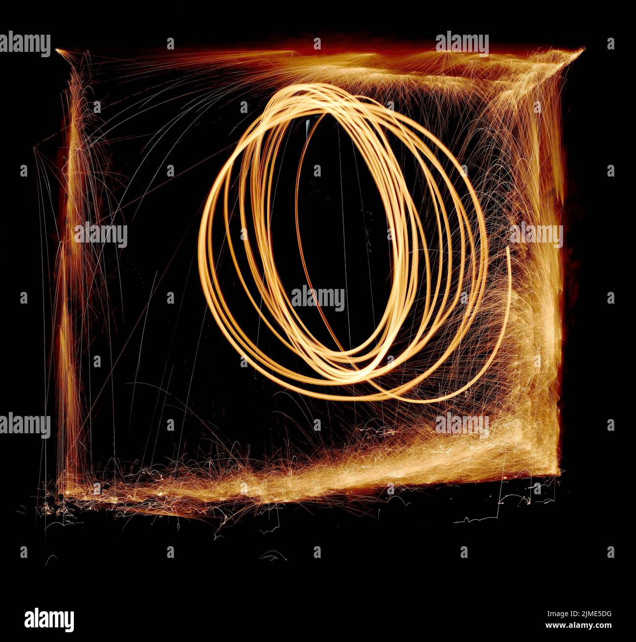 Steel wool spinning in a tunnel, throwing off yellow and orange sparks