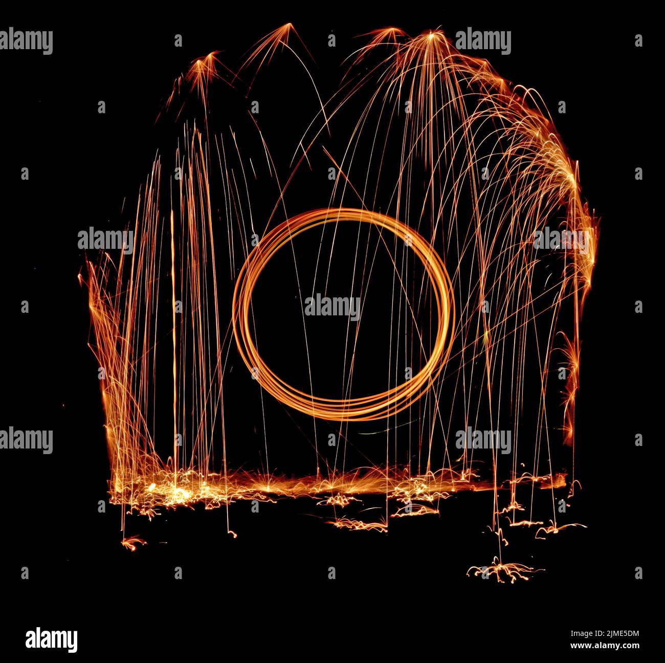 Steel wool spinning in a tunnel, throwing off yellow and orange sparks