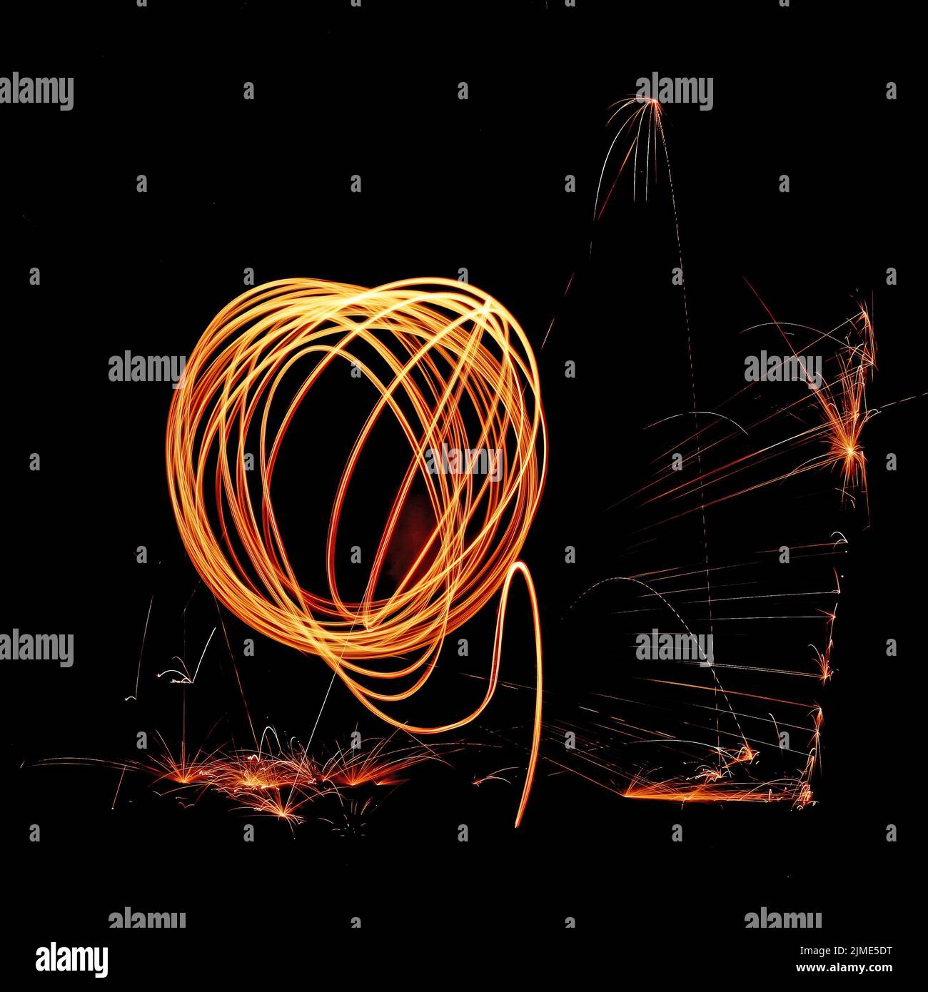 Steel wool spinning in a tunnel, throwing off yellow and orange sparks