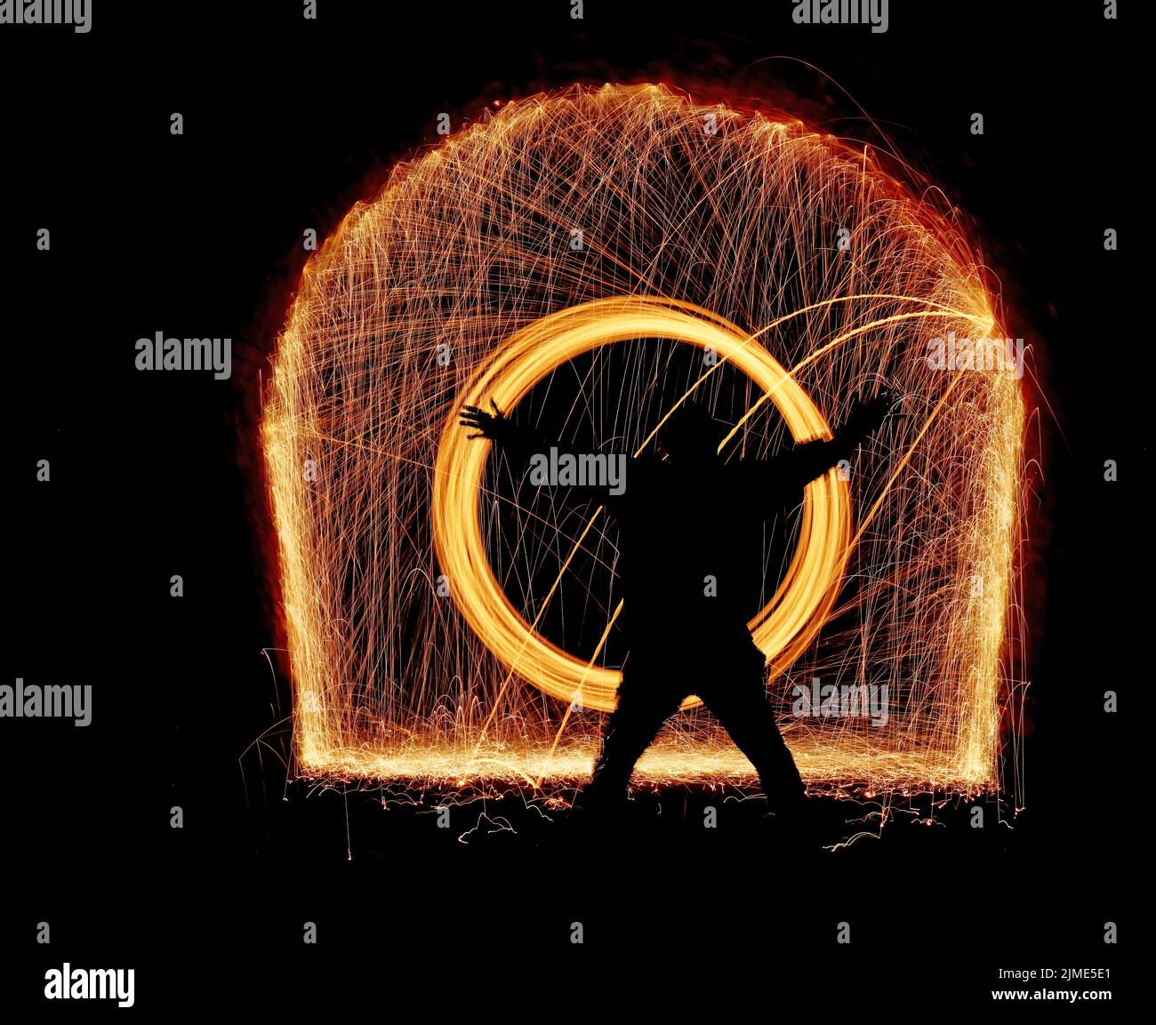 Steel wool spinning in a tunnel, throwing off yellow and orange sparks