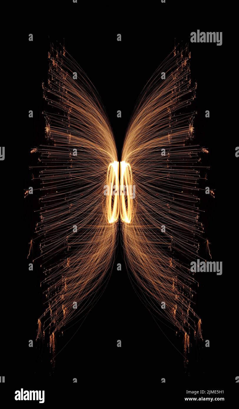 Steel wool spinning on a beach , throwing off yellow and orange sparks