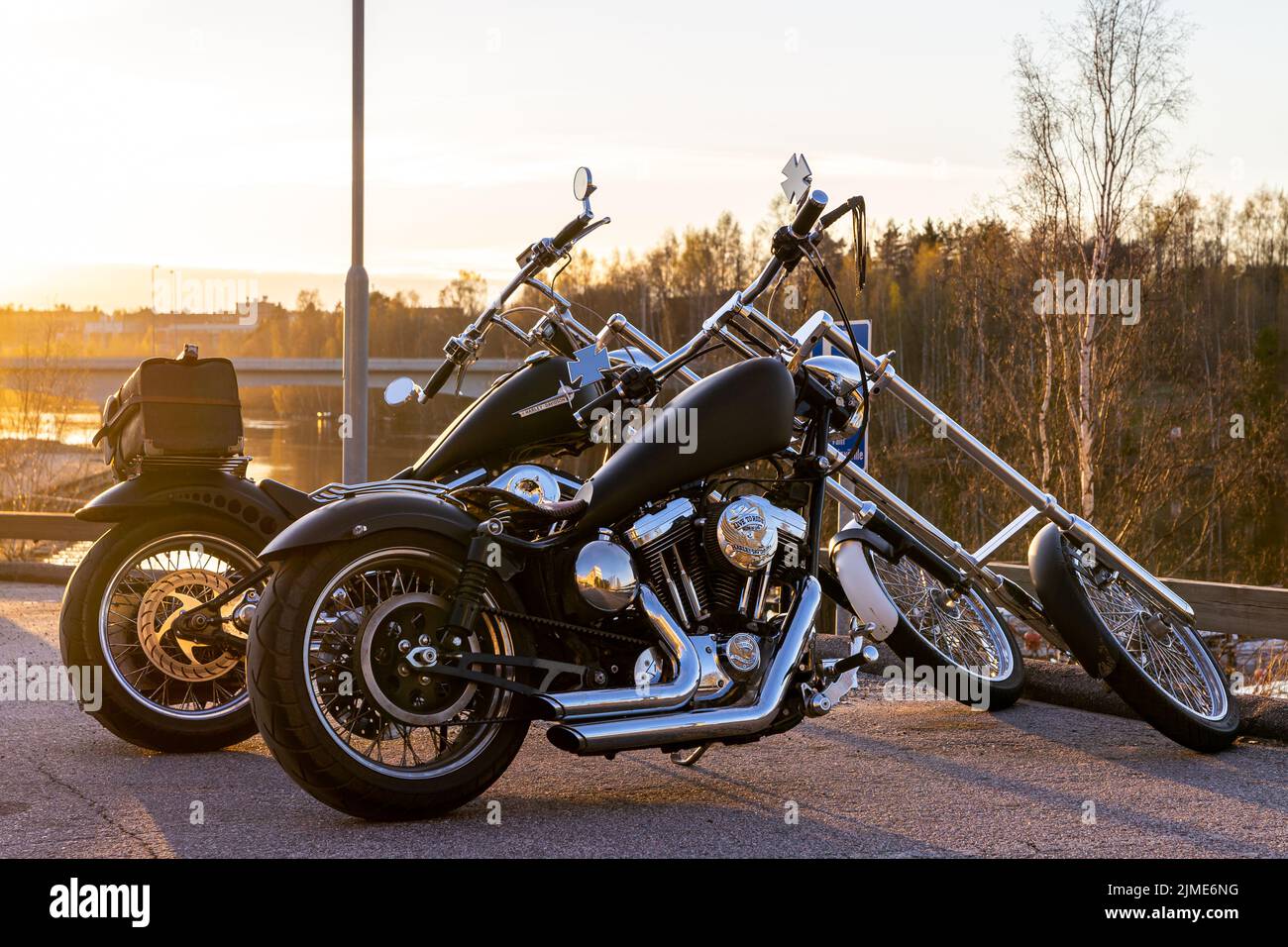 2 long fork chopper Harley Davidson motorcycles side by side in the evening sun. Not factory-made, self-built. Stock Photo