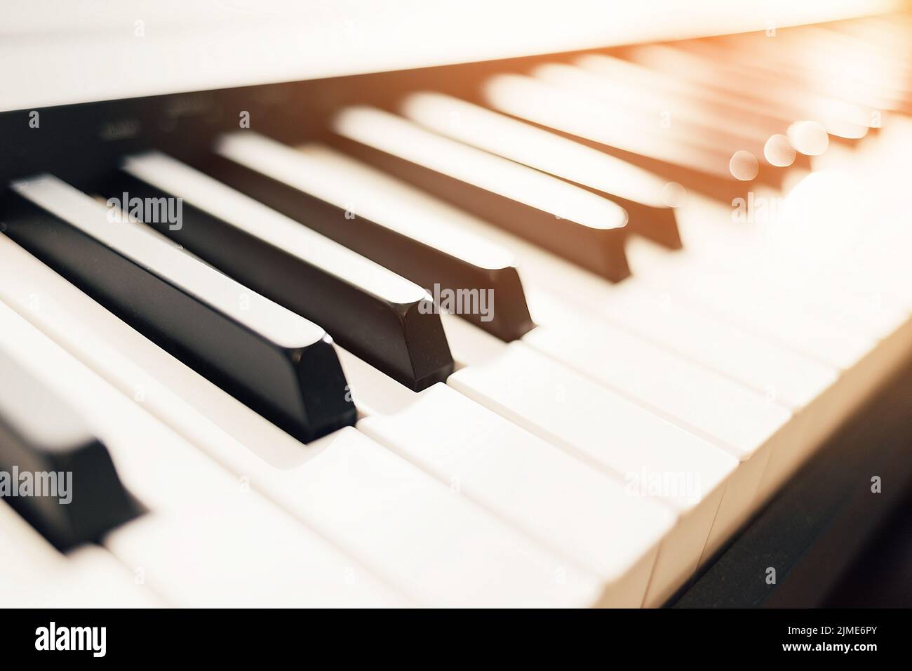 These are closeup digital piano keys with a side light of sunlight