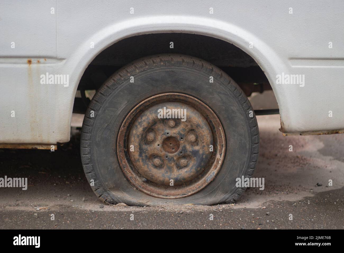 A deflated car wheel. Punctured tire. Stock Photo